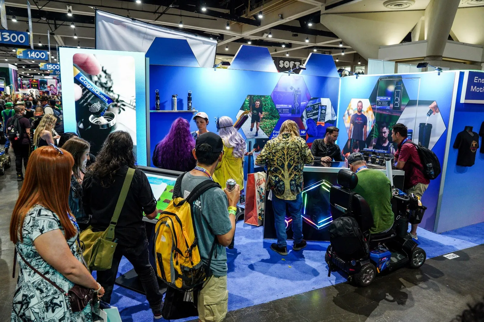 Visitors crowded around a bright blue exhibition booth with a touchscreen game, at New York Comic Con